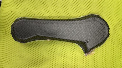 Unfinished composite leg blank on a yellow surface.